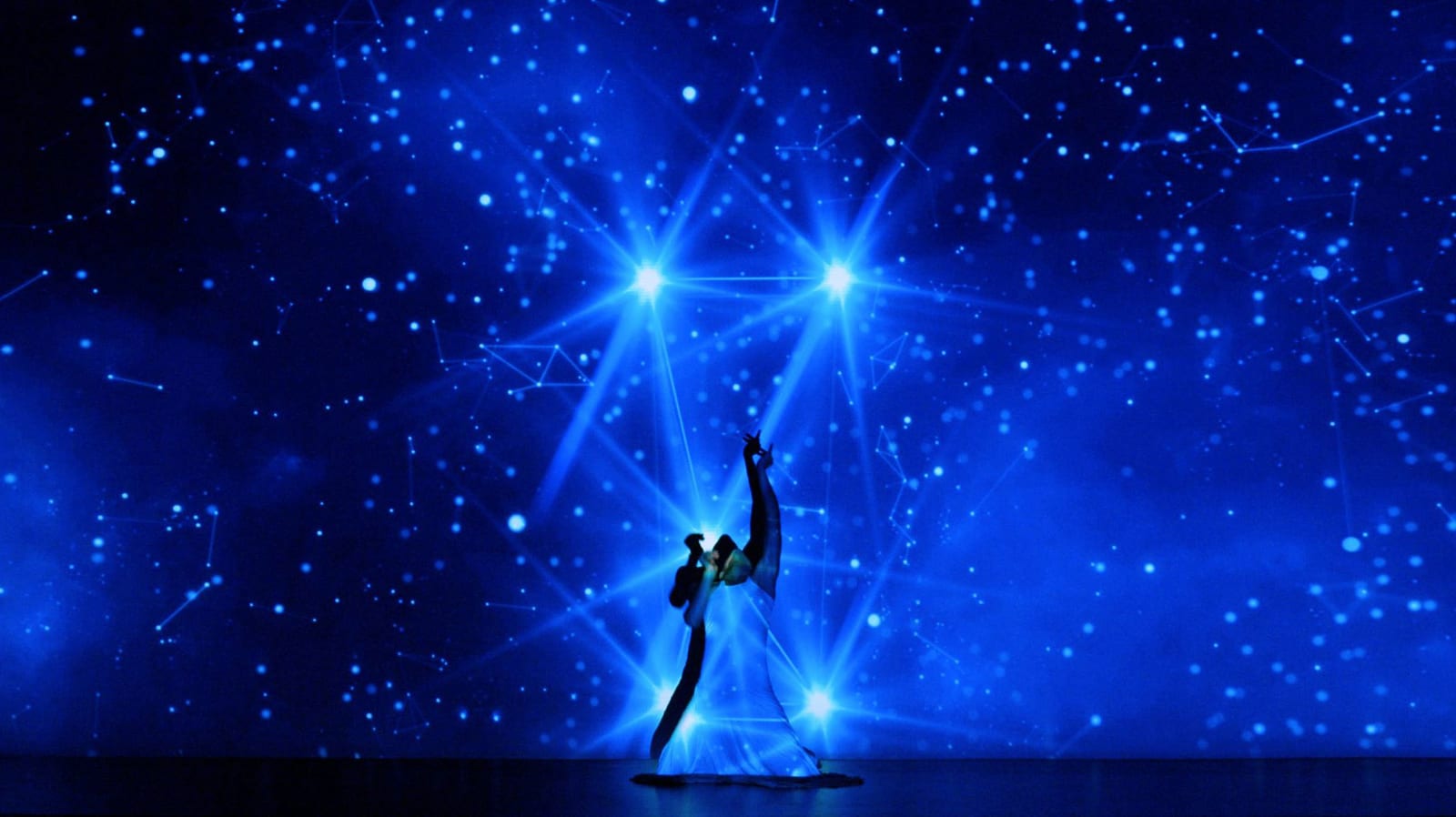 A performer moving through a deep-blue audiovisual environment